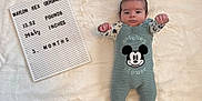 Waylon is registered to the contest to win money with this photo: baby, baby_clothes, blanket, cute, face, feet, hands, indoor, infant, letterboard, lying_down, mickey_mouse, milestone_board, neutral_expression, newborn, nursery, overalls, photography, portrait, soft_texture