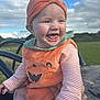 Kyla joined the competition — help win amazing prizes! baby, child, pumpkin_costume, orange_hat, striped_clothing, smiling, happy, outdoor, grass, cloudy_sky, seasonal, costume, cute, person, portrait, fall, nature, greenery, hands, joy
