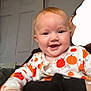 Kyla joined the competition — help win amazing prizes! baby, child, smiling, pumpkin_pajamas, indoor, person, face, hand, door, clothing, happy, infant, adult, holding, portrait, cute, orange, white, black, background