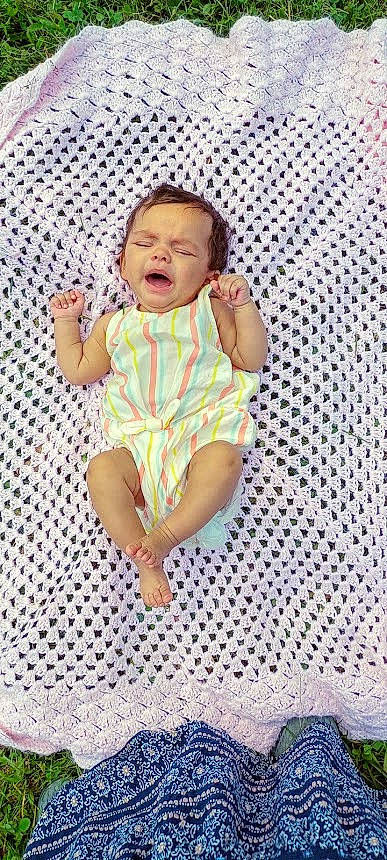 Juniper is registered to the contest to win money with this photo: baby, baby_products, baby_toddler_clothing, child, collar, comfort, fun, happy, infant_bodysuit, linens, pattern, person, portrait_photography, sitting, sleeve, sorrow, thumb, toddler