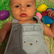 Gatlin is registered to the contest to win money with this photo: baby, infant, easter_eggs, colorful, blue_overall, bunny_pocket, blanket, laying_down, curious, face, cute, child, indoor, soft_light, skin, expression, hand, toy, holiday, spring