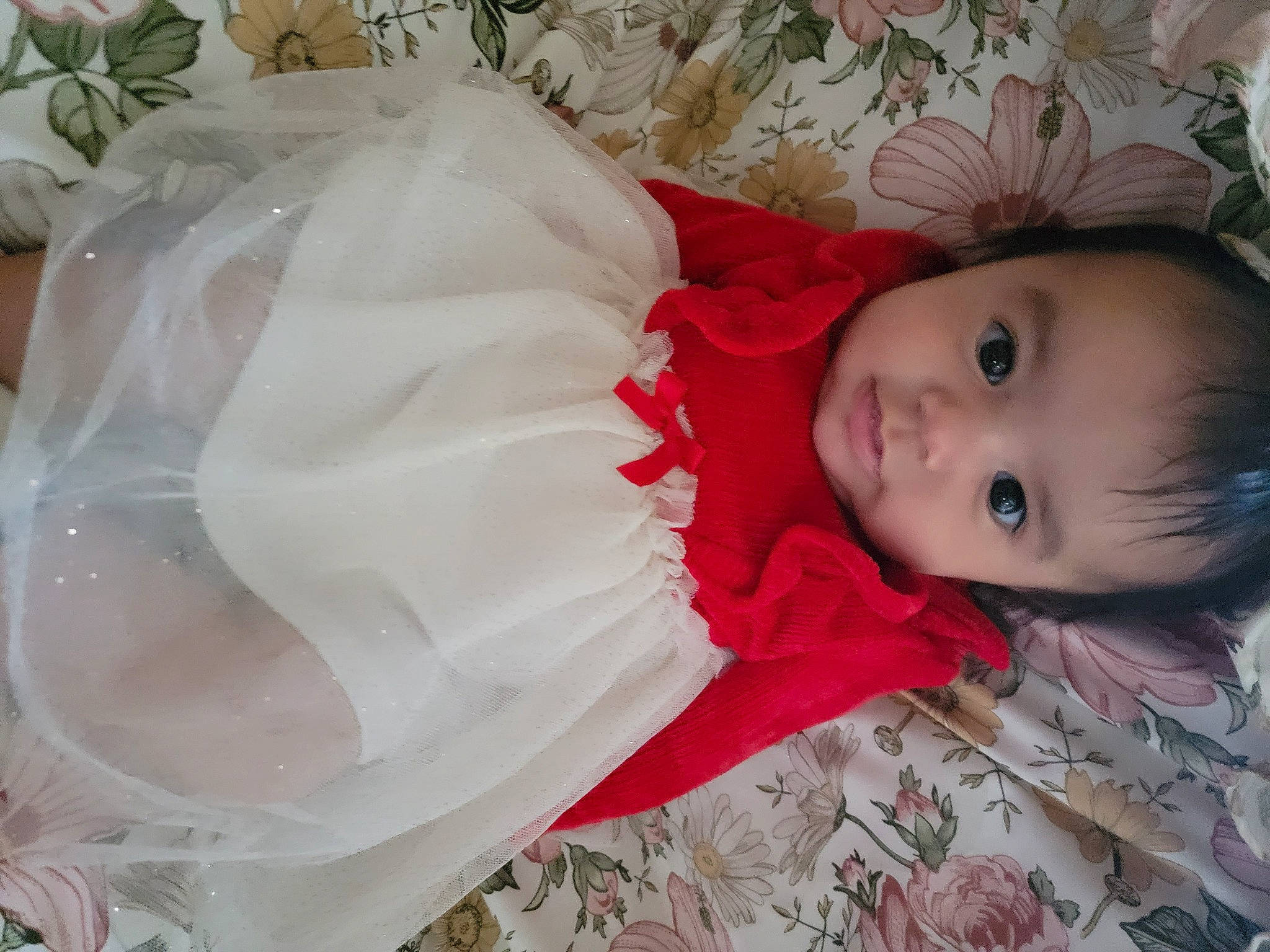 Leilani is registered to the contest to win money with this photo: arm, baby, baby_toddler_clothing, child, comfort, dress, embellishment, event, facial_expression, happy, headgear, headpiece, iris, lip, pattern, person, skin, sleeve, smile, toddler