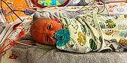 Luca James joined the competition — help win amazing prizes! newborn, baby, pacifier, blanket, hospital, medical_tubes, towel, bed, infant, cute, animal_pattern, wrapped, lying_down, face, eyes_open, indoors, healthcare, care, person, portrait