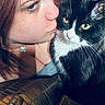 Athena joined the competition — help win amazing prizes! woman, cat, black_and_white_cat, face, green_eyes, affection, close_up, indoor, cushion, kiss, pet, fur, necklace, portrait, human, animal, love, cozy, furniture, texture