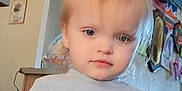 Rubie is registered to the contest to win money with this photo: toddler, child, indoor, gray_tshirt, blonde_hair, curious_expression, wall_decor, colorful_bunnies, text_on_clothing, person, young_child, casual_clothing, home_interior, artwork, light, floor, hand, portrait, cute, smile