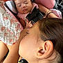 baby, child, sleeping, car_seat, seatbelt, blanket, floral, cloth, closeup, face, ear, hand, resting, peaceful, young_child, infant, toddler, pink, person, transportation