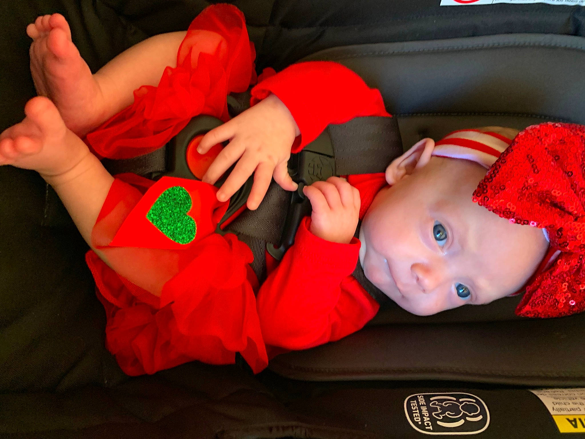 Zoee is registered to the contest to win money with this photo: baby, baby_toddler_clothing, child, comfort, eye, fun, gesture, hand, head, headwear, human_leg, lap, mammal, mouth, orange, person, red, sock, thigh, toddler