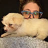 person, dog, glasses, blanket, indoor, cute, pet, fluffy, white_dog, casual, resting, closeup, face, cozy, home, comfort, young_adult, relaxed, text_overlay, snapshot
