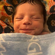 Omari joined the competition — help win amazing prizes! newborn, baby, infant, sleeping, smiling, swaddled, blanket, portrait, face, head, closed_eyes, peaceful, cozy, indoors, close_up, patterned_blanket, soft_lighting, dark_hair, child, photography