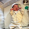 Omari joined the competition — help win amazing prizes! newborn, baby, infant, child, portrait, lying_down, smiling, happy, face, hands, fists, hooded_outfit, jumpsuit, white_clothing, bassinet, crib, star_pattern, pacifier, blanket, nursery