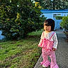 Esther Pham is registered to the contest to win money with this photo: toddler, child, outdoor, sidewalk, grass, bush, tree, fence, blue_fence, clothing, pink_clothing, plaid_pattern, long_sleeve_shirt, oversized_pants, person, daylight, nature, curious_expression, standing, shoes