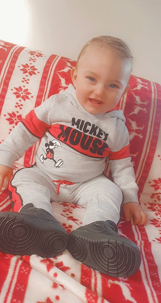 Juan a rejoint le concours — aidez-le/la à gagner de superbes lots ! baby, baby_toddler_clothing, carmine, cheek, child, comfort, couch, face, human_body, lap, linens, long_sleeved_t_shirt, mouth, nightwear, nose, pajamas, person, sitting, sleeve, sock