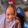 Amara joined the competition — help win amazing prizes! child, smiling, braids, beads, hair, haircut, salon_chair, plastic_cape, living_room, sofa, pillow, earrings, happy, portrait, indoor, person, hairstyle, couch, home, cute
