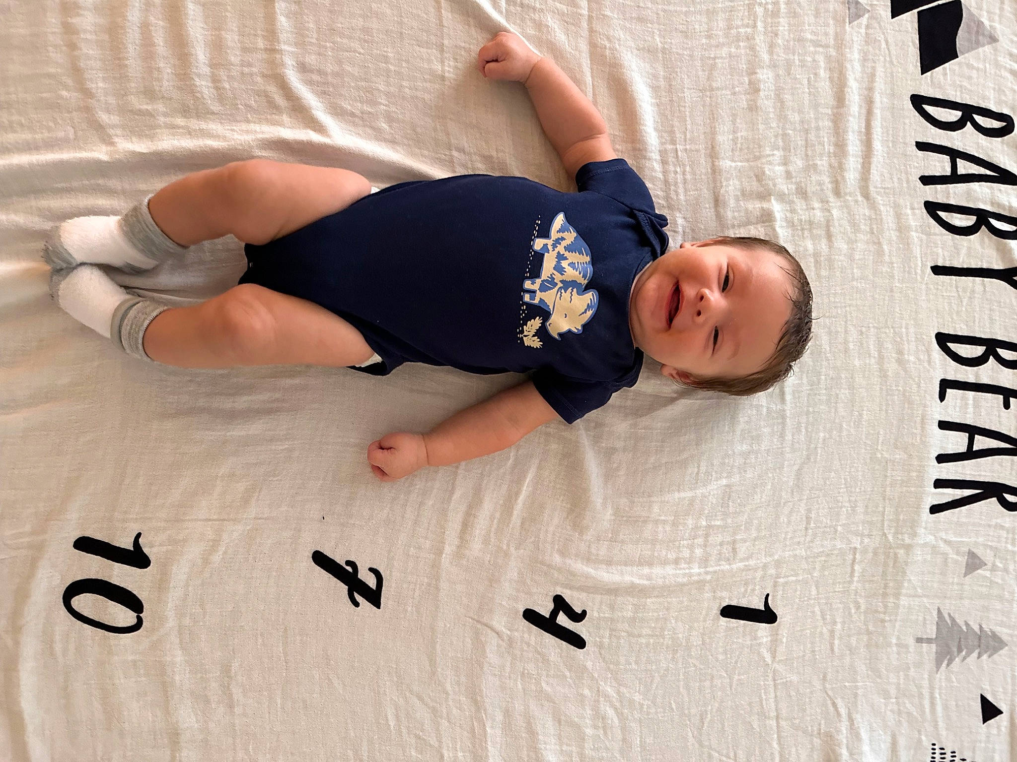 Octavian is registered to the contest to win money with this photo: baby, baby_sleeping, baby_toddler_clothing, child, comfort, elbow, font, foot, happy, human_leg, knee, linens, pattern, person, room, sitting, sleeve, t_shirt, textile, thigh