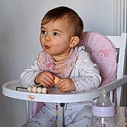 Luna participe au concours pour gagner de l'argent avec cette photo : baby, beads, bib, bottle, chair, child, cute, expression, face, feeding, hair, hands, highchair, indoor, onesie, portrait, snack, table, toddler, toy