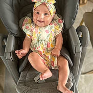 Zélie a rejoint le concours — aidez-le/la à gagner de superbes lots ! baby, child, smiling, infant, headband, floral_dress, baby_seat, gray_seat, happy, cute, indoors, person, legs, feet, arm, skin, seat_belt, comfort, joy, portrait