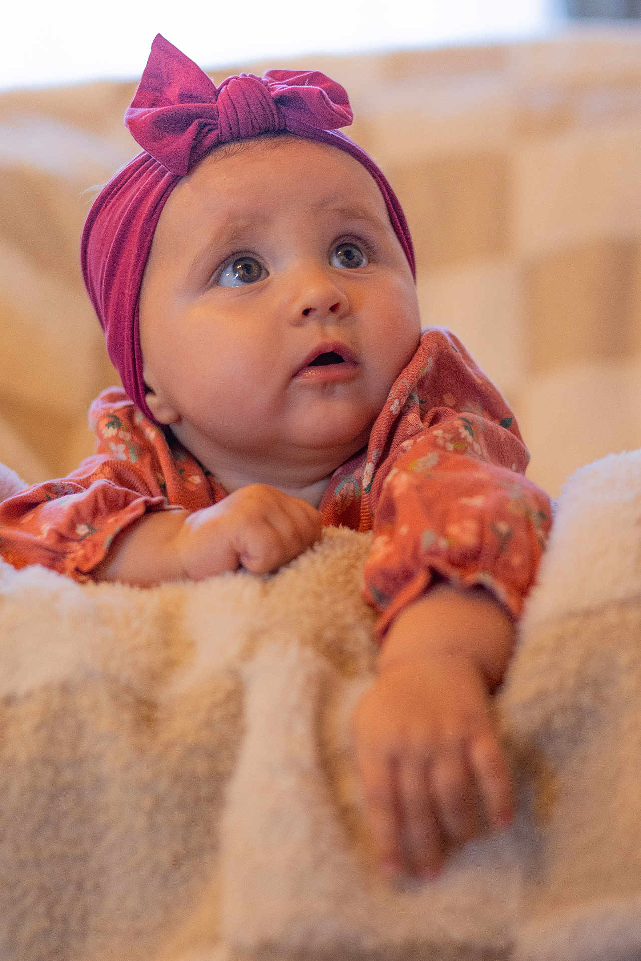 Zélie participe au concours pour gagner de l'argent avec cette photo : baby, blanket, bow, child, closeup, clothing, cute, expression, face, hand, headband, indoors, infant, person, portrait, skin, sleeve, soft_lighting, warm_colors, young
