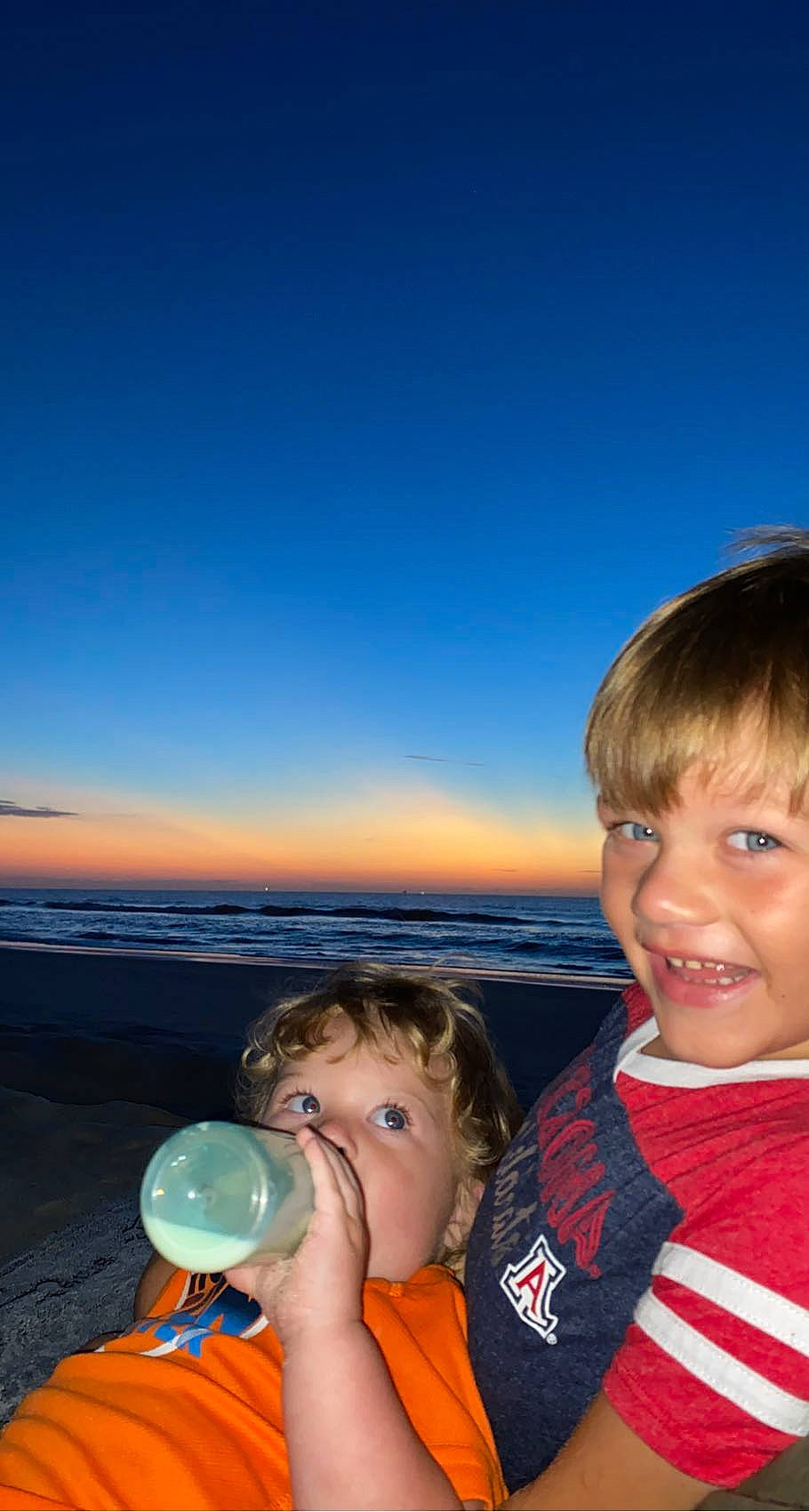 Curtis is registered to the contest to win money with this photo: bottle, cloud, drink, drinking, flash_photography, fun, gesture, happy, horizon, joy, leisure, morning, people_in_nature, person, plastic_bottle, sky, smile, summer, t_shirt, toddler