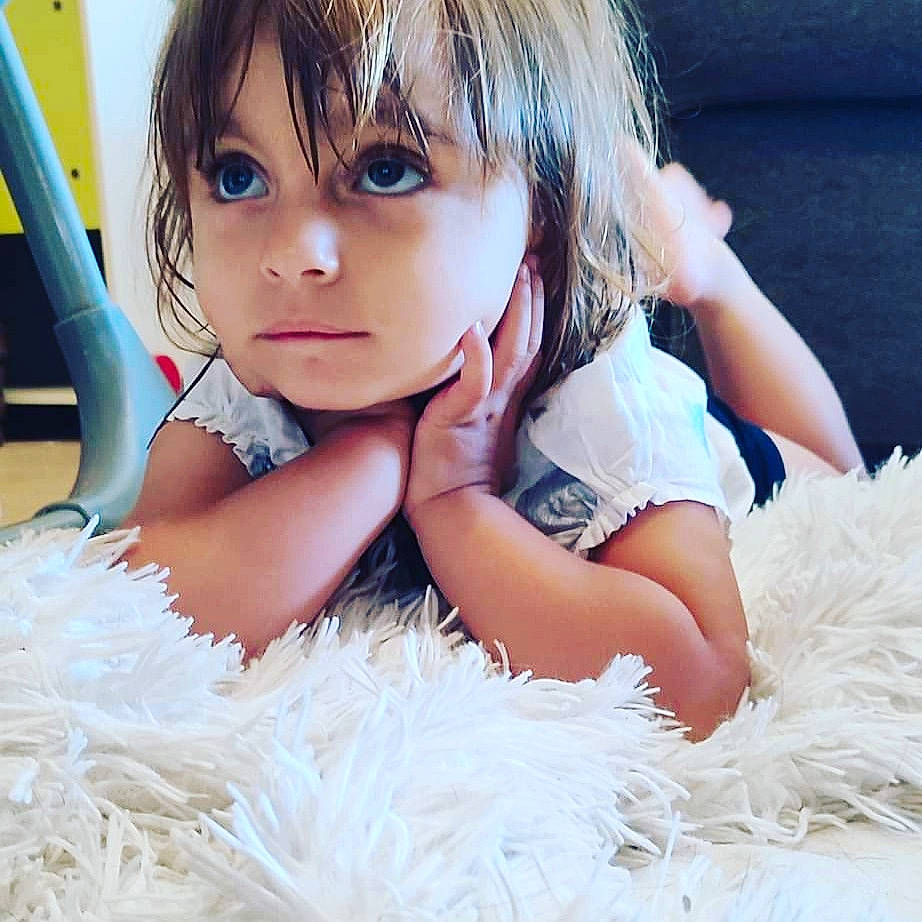 Elya participe au concours pour gagner de l'argent avec cette photo : bangs, brown_hair, child, eye, eyelash, fashion_accessory, flash_photography, fun, fur, happy, hime_cut, iris, long_hair, person, sitting, textile, thigh, toddler, toy, white