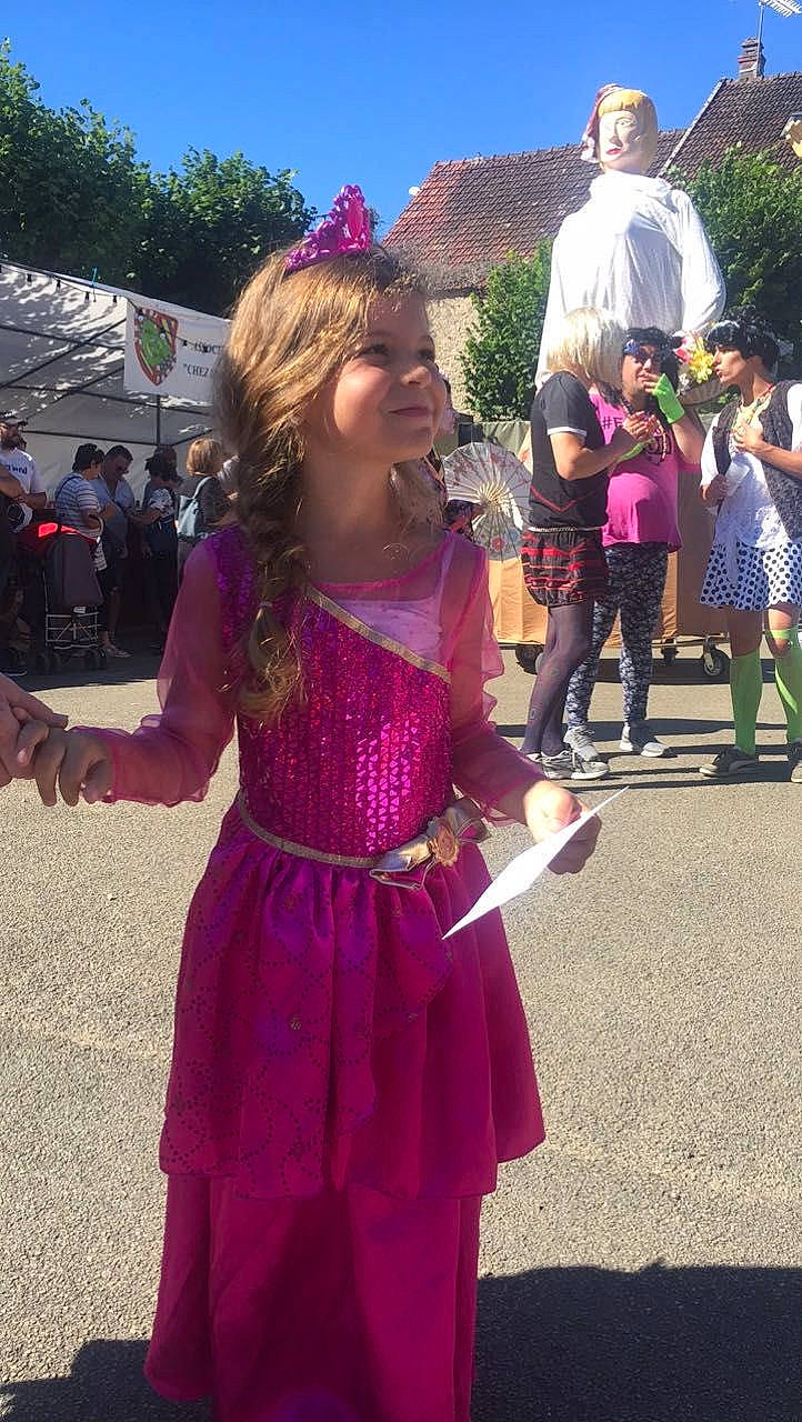 Noémie participe au concours pour gagner de l'argent avec cette photo : child, community, crowd, dress, event, fun, happy, headwear, jewellery, joy, leisure, magenta, person, pink, pole, public_event, purple, recreation, sky, smile