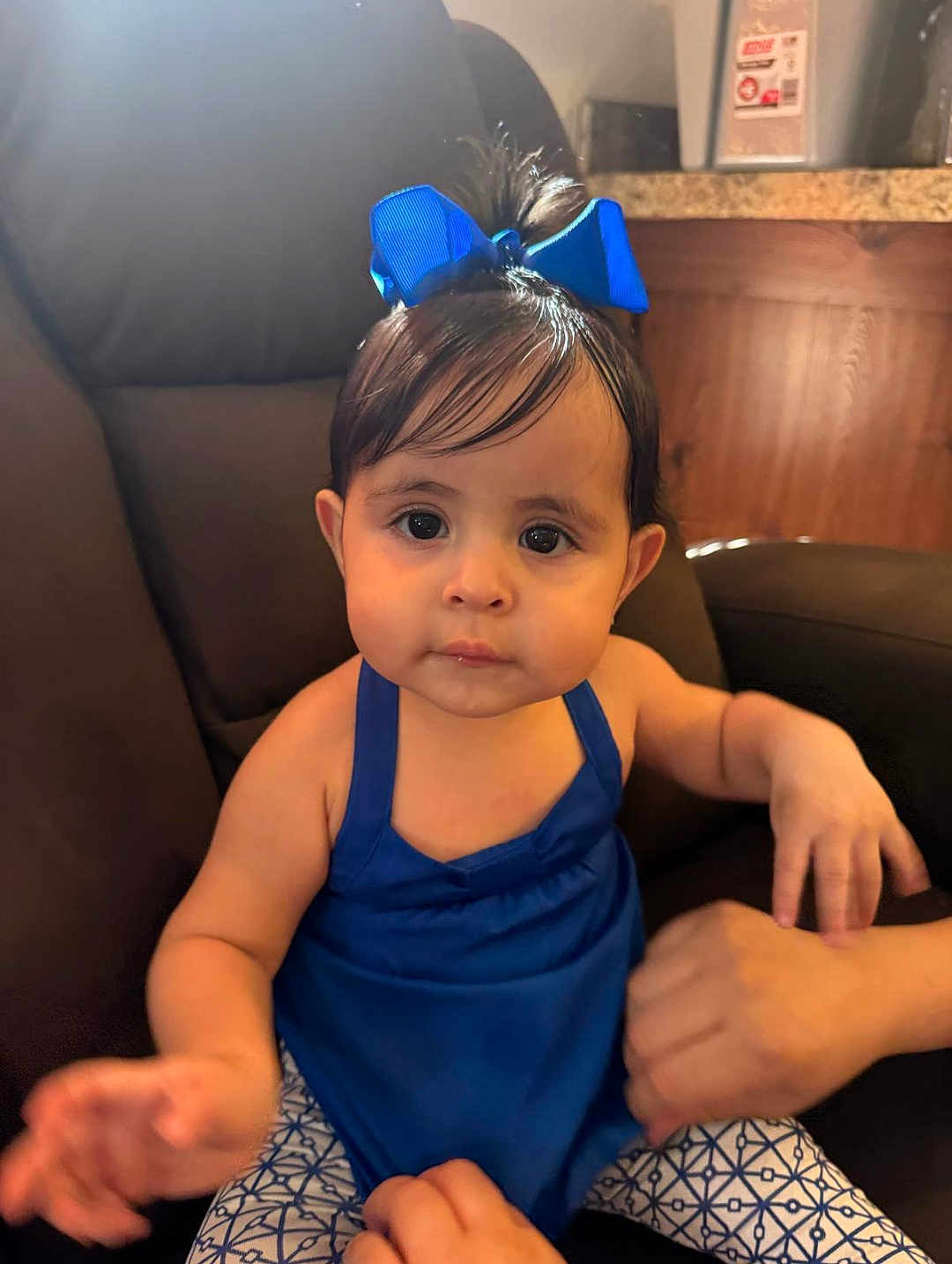 Kassandra joined the competition — help win amazing prizes! toddler, child, baby, blue_dress, blue_bow, indoor, sitting, chair, person, hands, cute, portrait, young_child, face, hair, patterned_pants, skin, expression, furniture, human