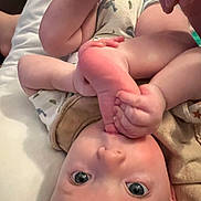 Hunter is registered to the contest to win money with this photo: baby, infant, foot, hand, onesie, skin, lying_down, curious, close_up, blue_eyes, playful, cozy, soft_skin, bed, blanket, toddler, child, human, indoor, cute