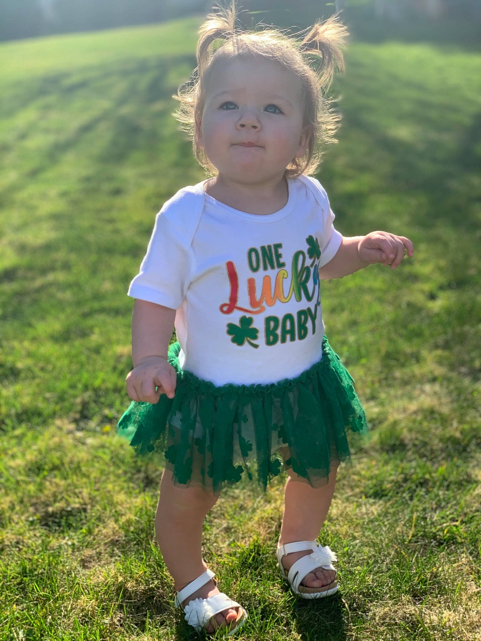 Arielle is registered to the contest to win money with this photo: baby_toddler_clothing, blond, child, cool, eye, face, fun, grass, grass_family, grassland, green, happy, head, meadow, people_in_nature, person, sleeve, summer, sunlight, t_shirt