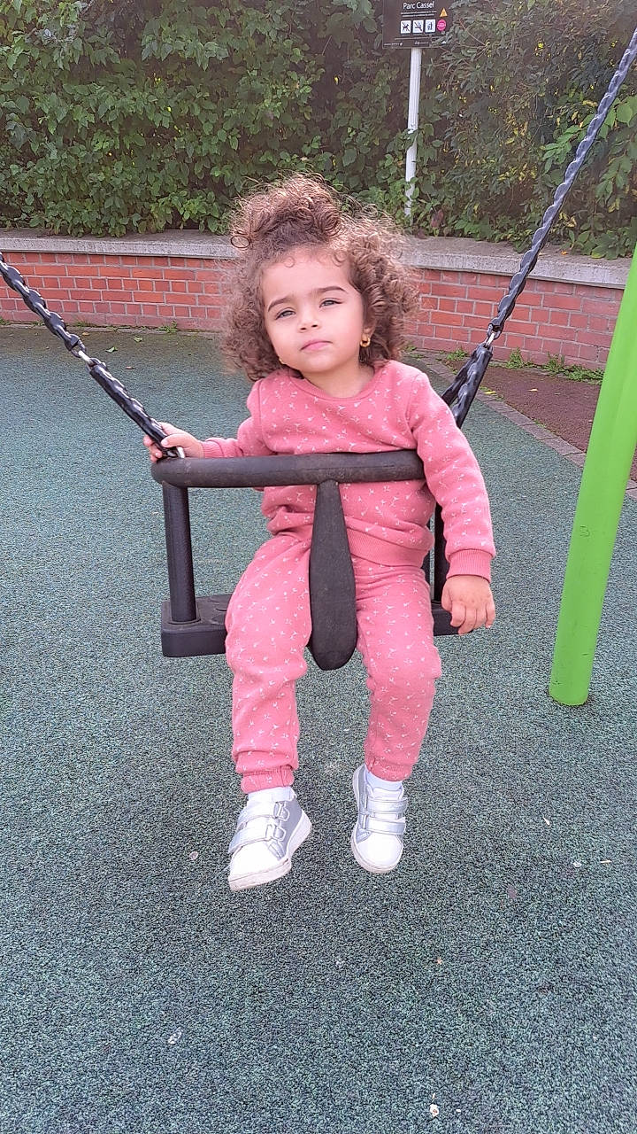 Nour Kherri a rejoint le concours — aidez-le/la à gagner de superbes lots ! baby, baby_toddler_clothing, child, city, fun, grass, happy, head, leisure, magenta, outdoor_play_equipment, people_in_nature, person, plant, play, playground, recreation, road_surface, sitting, swing