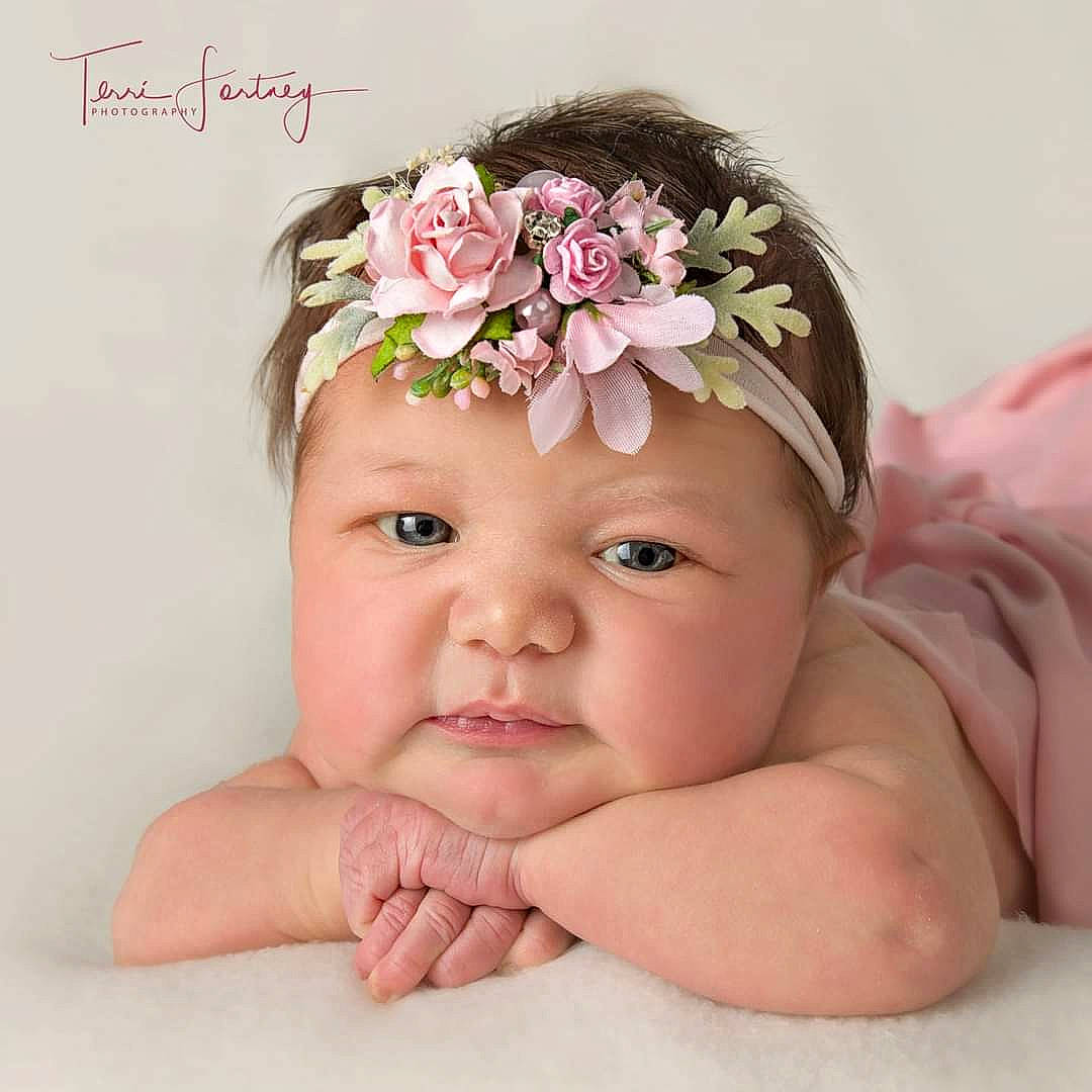 Kora is registered to the contest to win money with this photo: artificial_flower, baby, baby_toddler_clothing, crown, fashion_accessory, finger, flower, hair_accessory, happy, headband, headpiece, headwear, jewellery, nail, peach, person, petal, pink, skin, textile