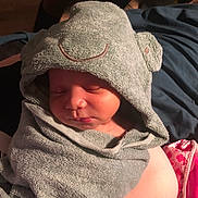 Theodore is registered to the contest to win money with this photo: baby, sleeping, towel, hooded_towel, infant, face, wrapped, soft_texture, cute, peaceful, person, arm, indoor, fabric, child, newborn, cozy, relaxed, resting, blanket