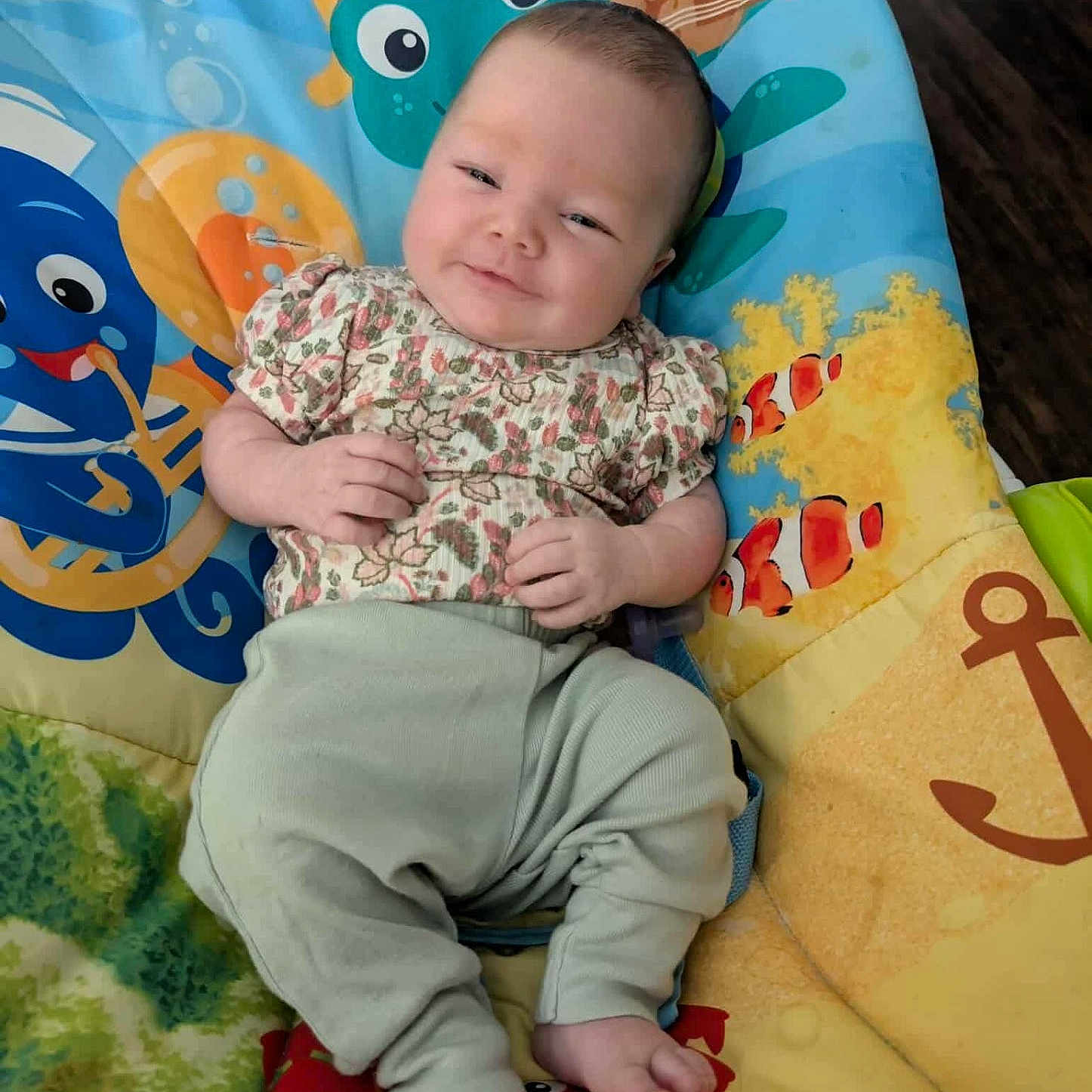 Aurelia is registered to the contest to win money with this photo: anchor, baby, cartoon, clothing, colorful, cushion, face, fish, floor, happy, indoor, infant, octopus, pants, person, relaxing, sea_creatures, shirt, smile, underwater_theme