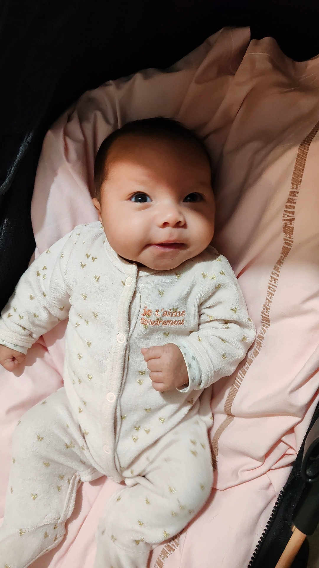 Adélina a rejoint le concours — aidez-le/la à gagner de superbes lots ! baby, infant, onesie, white_clothing, golden_hearts, pink_blanket, lying_down, face, smile, cute, child, newborn, soft_fabric, indoor, portrait, closeup, adorable, baby_clothes, small_hands, sleepwear