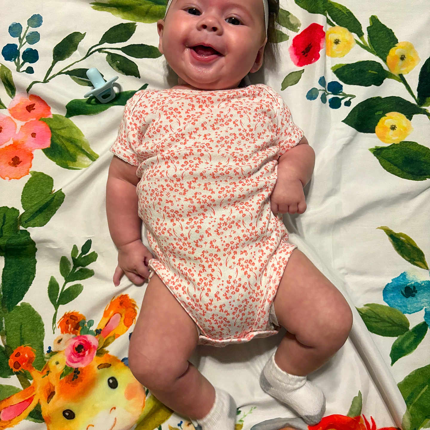 Gracelyn- Claire joined the competition — help win amazing prizes! animal_print, baby, baby_clothing, blanket, child, colorful, cute, elephant, floral_pattern, giraffe, happy, headband, indoors, infant, lying_down, onesie, pacifier, portrait, smiling, socks