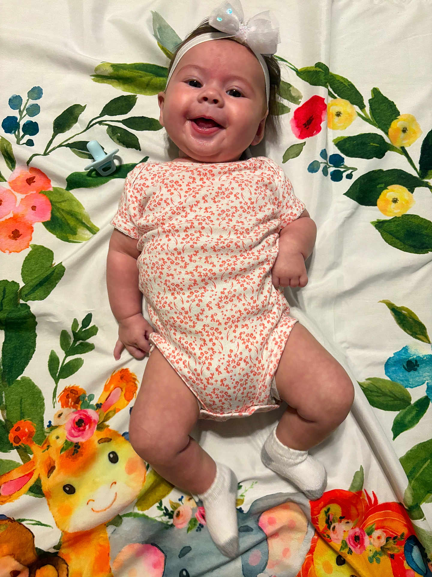 Gracelyn- Claire joined the competition — help win amazing prizes! baby, infant, smiling, headband, onesie, socks, pacifier, blanket, floral_pattern, animal_print, giraffe, elephant, happy, cute, lying_down, child, portrait, colorful, indoors, baby_clothing