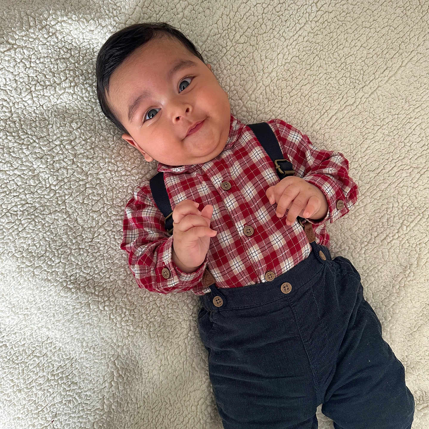 Zain joined the competition — help win amazing prizes! baby, blanket, casual_clothing, child, cozy, cute, fabric, face, feet, hands, happy, indoor, infant, lying_down, pants, plaid_shirt, portrait, smiling, suspenders, young_child
