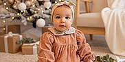 Aëlia a rejoint le concours — aidez-le/la à gagner de superbes lots ! baby, blanket, carpet, child, christmas_tree, couch, cute, decorations, festive, floor, gift, headband, holiday, indoors, portrait, present, sitting, smiling, tights, warm