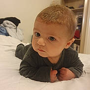 Loan a rejoint le concours — aidez-le/la à gagner de superbes lots ! baby, infant, child, face, eyes, lying_down, bed, blanket, bedding, pajamas, sleeves, hands, portrait, indoors, bedroom, shelf, furniture, curious_expression, close_up, soft_lighting