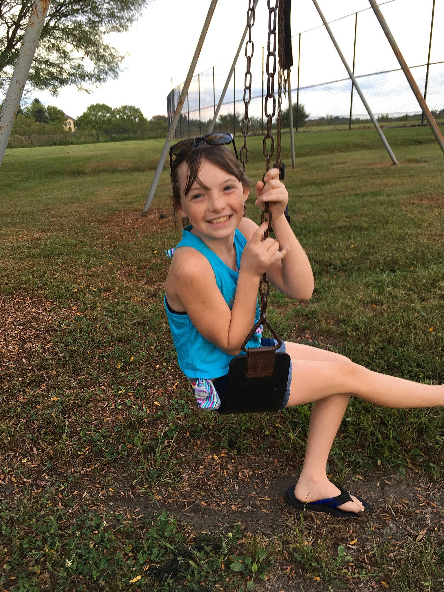 Keirra is registered to the contest to win money with this photo: child, fun, grass, joint, joy, leg, outdoor_play_equipment, performance, person, photography, plant, playground, sitting, smile, style, summer, swing, tree, vacation