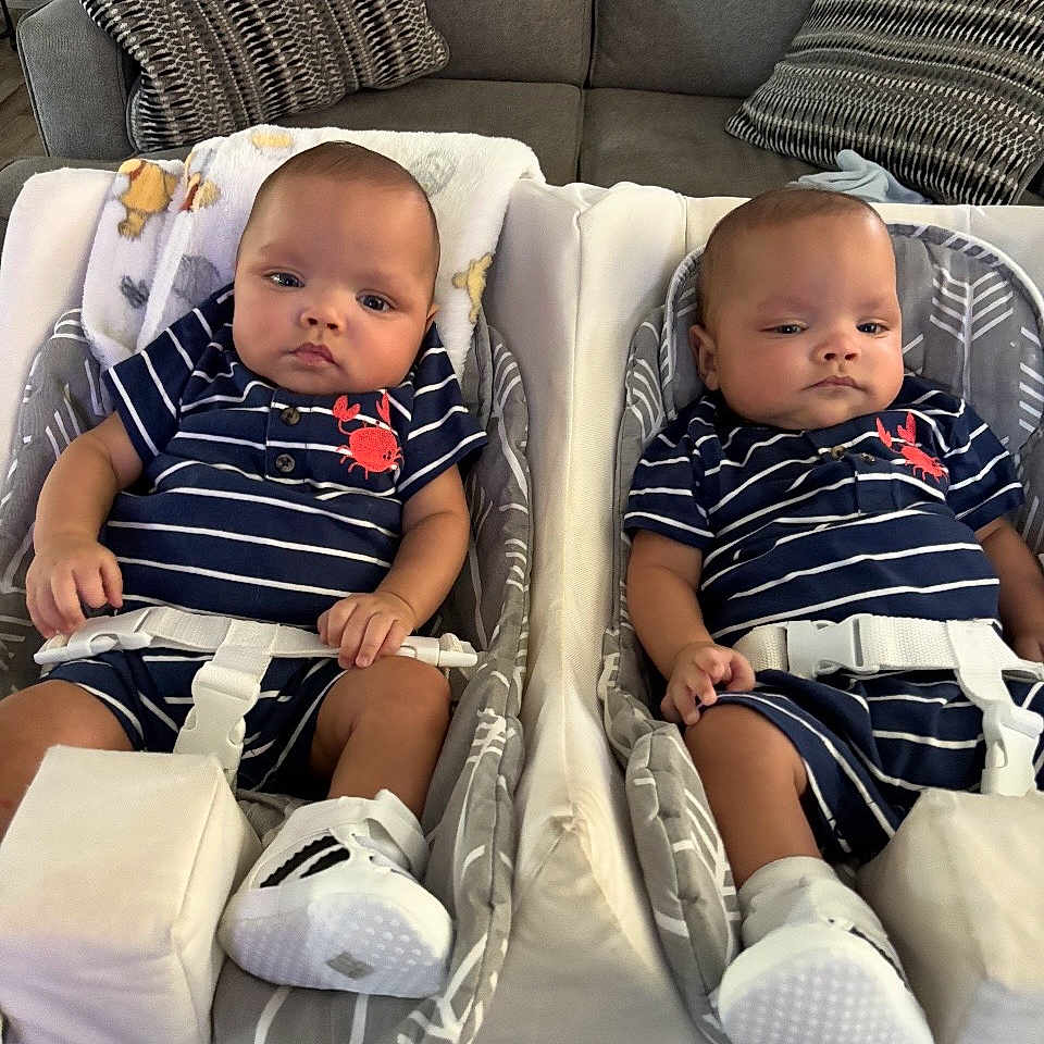Braxton N Greyson joined the competition — help win amazing prizes! babies, twins, infants, children, matching_outfits, striped_clothing, navy_blue, white, sneakers, baby_seats, bouncers, harnesses, couch, pillows, indoor, portrait, sitting, faces, family, cute