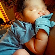 Adrian joined the competition — help win amazing prizes! baby, newborn, sleeping, infant, close_up, blue_clothing, mittens, cuddling, skin, arm, face, peaceful, indoor, warm_lighting, adult, tattoo, cozy, resting, child, portrait