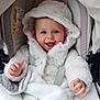 baby, infant, hooded_jacket, blanket, car_seat, stroller, smiling, blue_eyes, hands, face, hood, fur, seatbelt, safety_label, portrait, closeup, happy, cozy, child, clothing