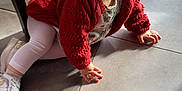 Valentina participe au concours pour gagner de l'argent avec cette photo : toddler, child, baby, crawling, red_sweater, white_leggings, white_shoes, floor, tile_floor, indoor, natural_light, chair, curious, smiling, young_child, person, casual_clothing, head, hands, eyes