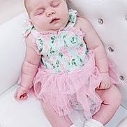 Brinley is registered to the contest to win money with this photo: baby, sleeping, crown, tiara, pink_tutu, white_chair, infant, cute, soft_lighting, floral_outfit, newborn, peaceful, adorable, portrait, child, socks, indoor, resting, small_hand, cute_fashion