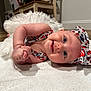 baby, infant, smiling, headband, bow, clothing, blanket, floor, indoor, happy, cute, child, portrait, toddler, person, face, skin, blue_eyes, cheerful, laying