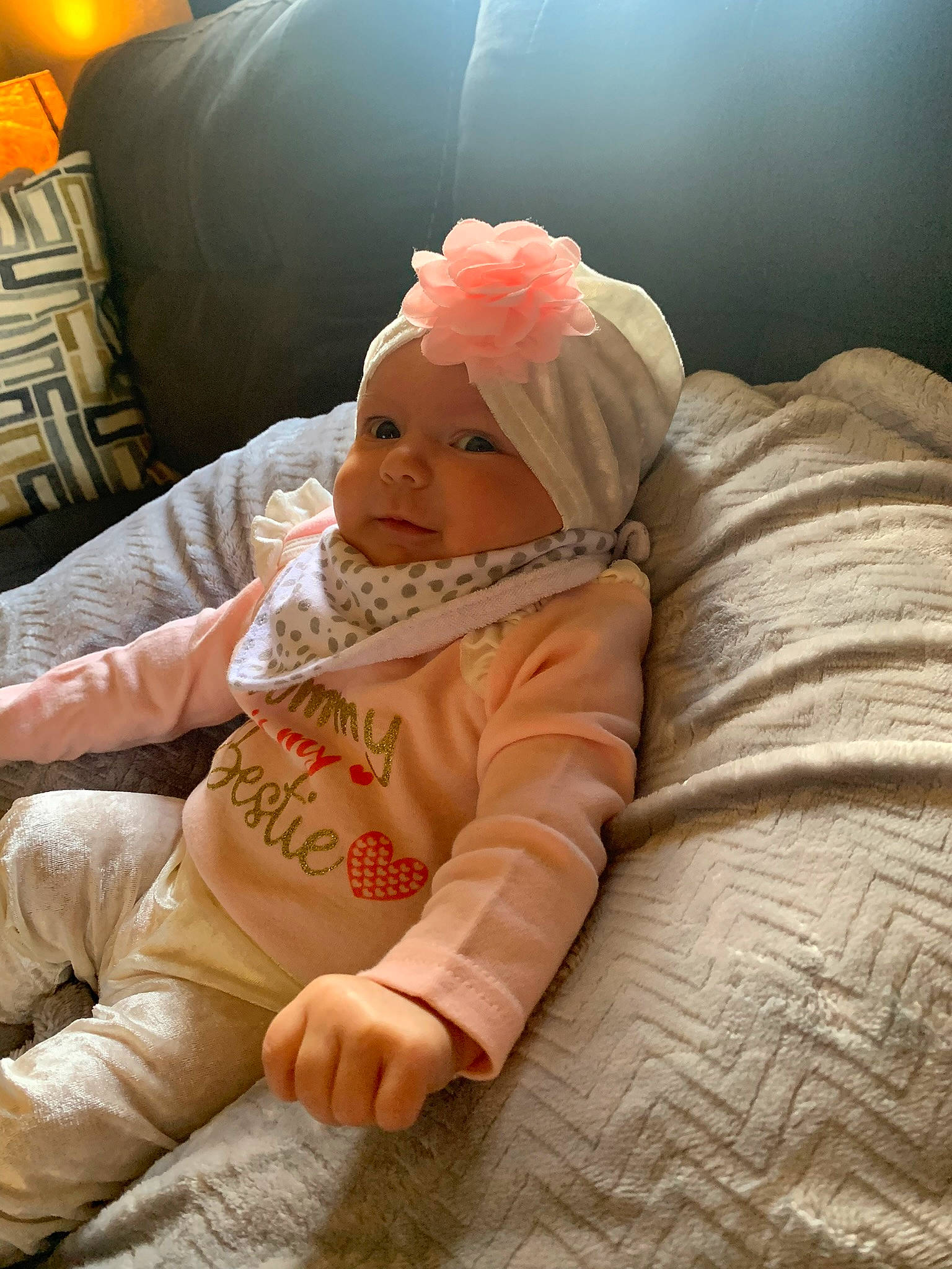 Willow is registered to the contest to win money with this photo: baby, baby_toddler_clothing, cheek, child, comfort, finger, flooring, foot, fun, grass, happy, head, headwear, human_body, lap, linens, orange, person, sitting, skin