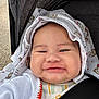 baby, child, smiling, hood, blanket, teddy_bear_pattern, stroller, face, cute, infant, clothing, portrait, chubby_cheeks, happy, outside, natural_light, closeup, babywearing, seatbelt, infant_clothing