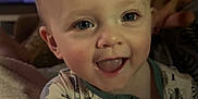 Hudson joined the competition — help win amazing prizes! baby, child, smiling, blanket, indoor, portrait, face, cute, happy, blue_eyes, clothing, person, infant, cozy, soft_texture, expression, young_child, toddler, hand, warmth