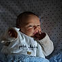 baby, bedding, blanket, blue_blanket, clothing, cozy, crib_sheet, cute, face, hand, indoor, infant, lying_down, newborn, onesie, portrait, skin, sleepy, soft_lighting, star_pattern