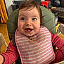Mia a rejoint le concours — aidez-le/la à gagner de superbes lots ! baby, bib, big_eyes, child, face, feeding, food_smear, green_chair, hair, happy, highchair, indoor, living_room, meal_time, messy, pink_clothing, portrait, smile, teeth, toddler
