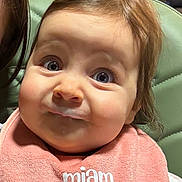 Mia participe au concours pour gagner de l'argent avec cette photo : baby, bib, blue_eyes, brown_hair, candid, close_up, drool, feeding_time, food_on_face, green_chair, indoor, infant, messy_face, milk, person, pink_bib, portrait, seat, skin, surprised_expression
